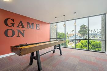 A pool table with the words "Game On" on the wall behind it at Lafayette Apartments, Los Angeles, California